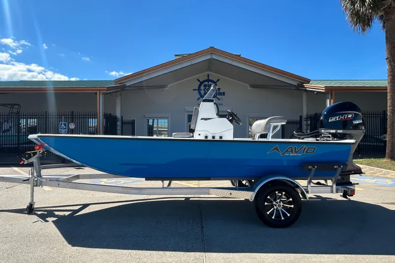 Slide: The Image of 2026 Avid 18 Rogue CC boat on trailer, parked outdoors under clear sky. - 0