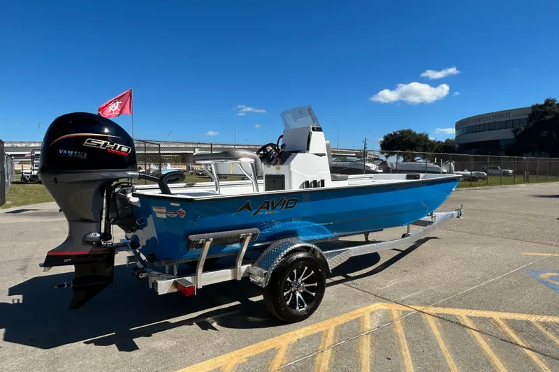 Slide: The Image of 2026 Avid 18 Rogue CC boat with Yamaha engine on trailer, parked outdoors. - 2