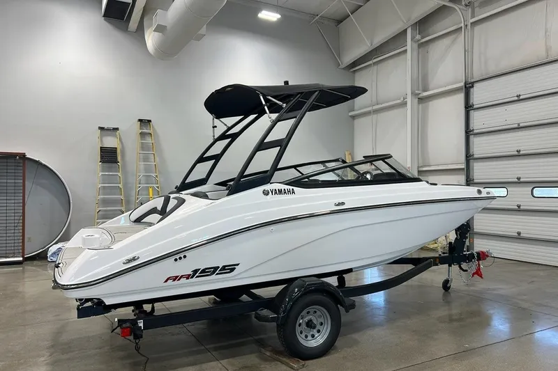The Image of 2025 Yamaha Boats AR195 in a showroom, featuring sleek design and modern architecture. - 0