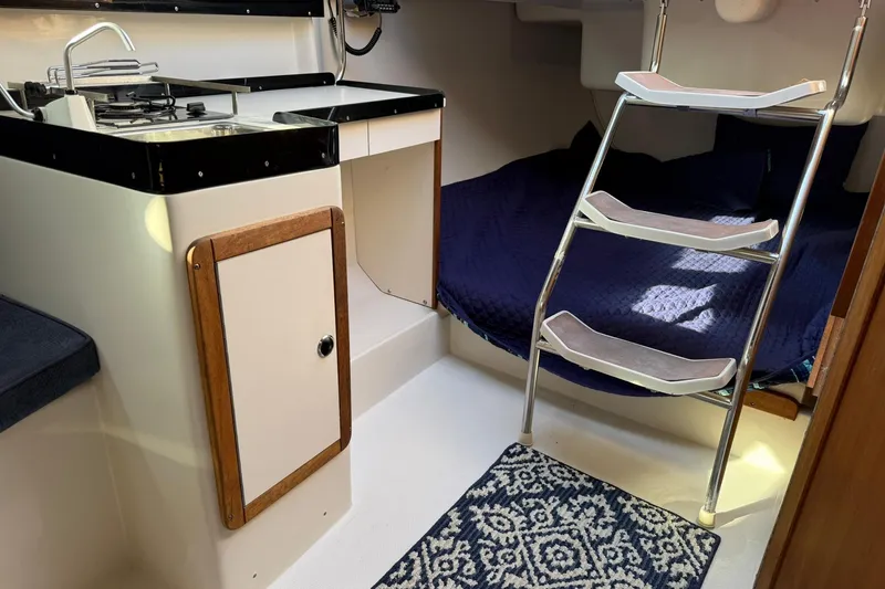 Slide: The Image of Interior of 2000 Catalina 250 MkII sailboat with compact kitchen and cozy sleeping area. - 11