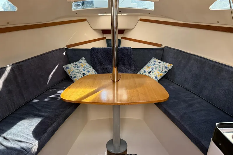 Slide: The Image of Interior of a 2000 Catalina 250 MkII sailboat with cozy seating and wooden table. - 14