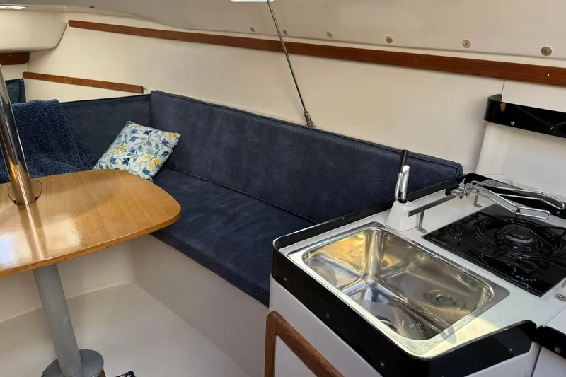 Slide: The Image of Interior of 2000 Catalina 250 MkII sailboat with kitchenette and seating area. - 16