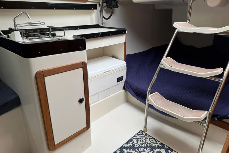Slide: The Image of Interior of 2000 Catalina 250 MkII sailboat with compact kitchen and cozy sleeping area. - 7