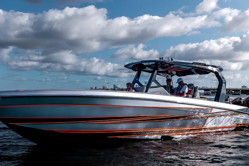 Slide: The Image of 2026 AMP 333 speedboat cruising on water under a partly cloudy sky. - 13