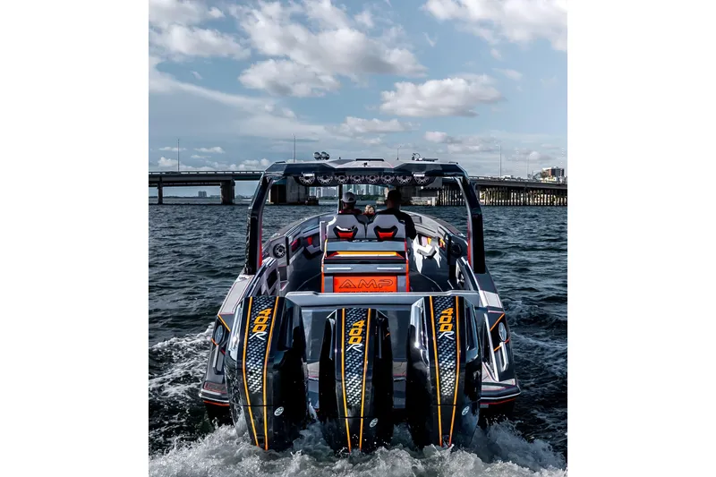 Slide: The Image of High-performance AMP 333 boat cruising on water, showcasing powerful engines, under a cloudy sky. - 15