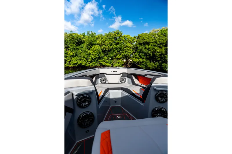Slide: The Image of 2026 AMP 333 boat interior with speakers, sleek design, and lush greenery background. - 23