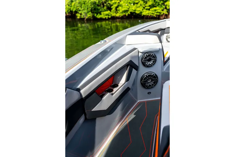 Slide: The Image of 2026 AMP 333 boat interior with sleek design, speakers, and cup holders by the water. - 24