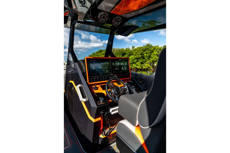 Slide: The Image of Futuristic AMP 333 boat cockpit with advanced digital dashboard, vibrant orange accents, and sleek design. - 39