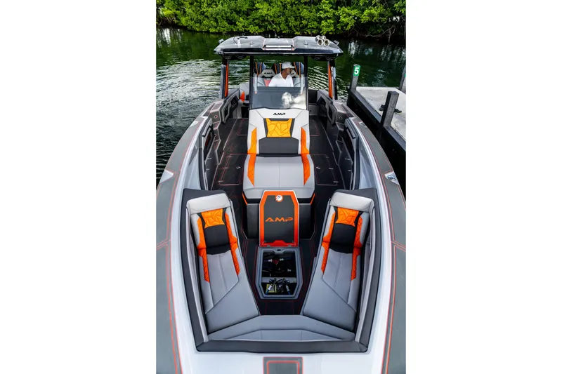 Slide: The Image of 2026 AMP 333 boat with sleek design, orange accents, docked by lush greenery. - 44