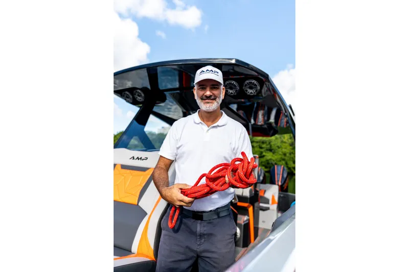 Slide: The Image of Man holding red rope on AMP 333 boat, 2026 model, under blue sky. - 46