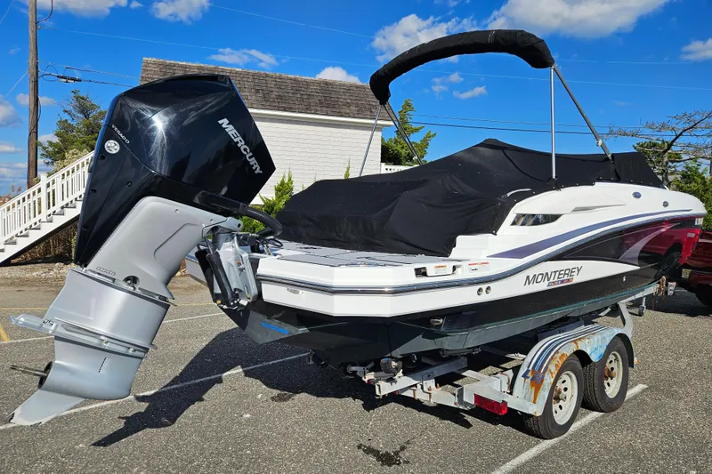 Slide: The Image of 2022 Monterey M-45 boat on trailer with Mercury outboard motor, parked outdoors. - 3
