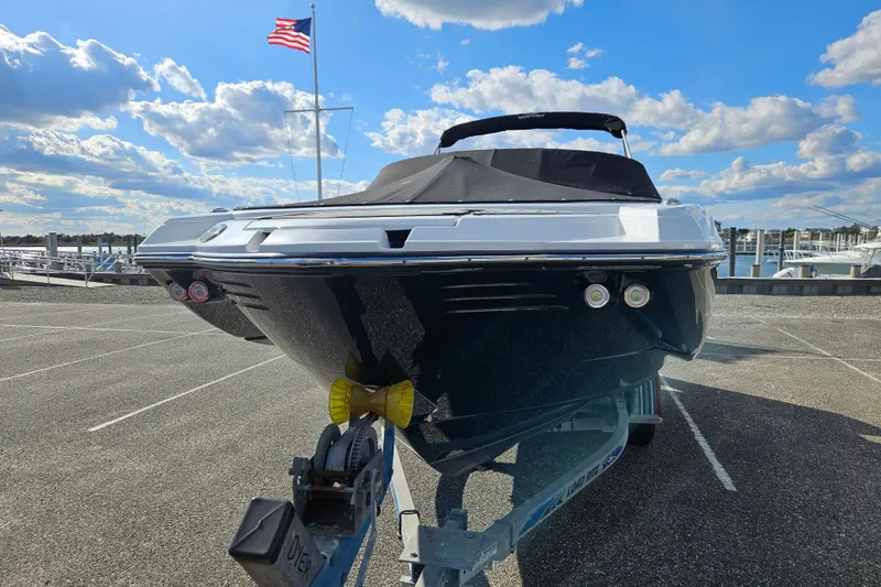Slide: The Image of 2022 Monterey M-45 boat on trailer, parked under a blue sky with clouds and an American flag. - 6