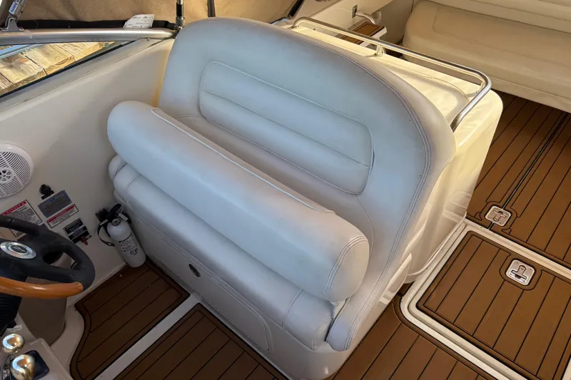 Slide: The Image of 2005 Sea Ray 290 Amberjack interior with white seating and wood flooring. - 12