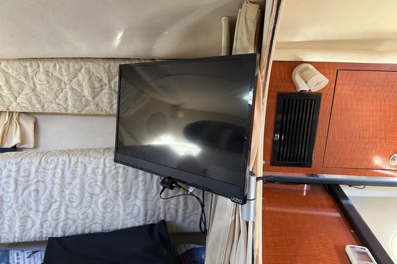 Slide: The Image of Interior of 2005 Sea Ray 290 Amberjack with mounted TV and wood cabinetry. - 17