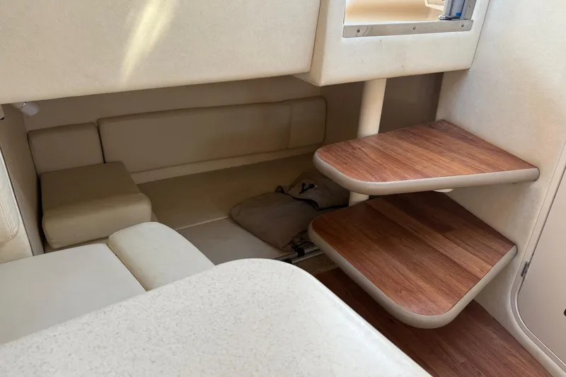 Slide: The Image of Interior of 2005 Sea Ray 290 Amberjack boat with wooden steps and beige seating. - 19