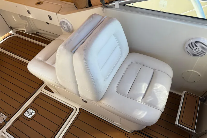 Slide: The Image of 2005 Sea Ray 290 Amberjack boat interior with white seating and wood flooring. - 8