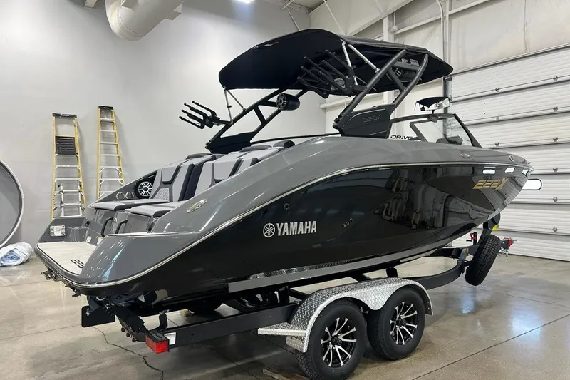 Slide: The Image of 2025 Yamaha Boats 222XD in showroom, sleek design, black finish, on trailer. - 3