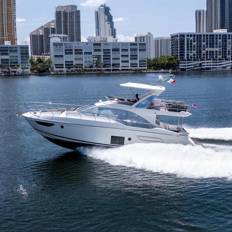 Slide: The Image of 2023 Azimut Fly 50 yacht cruising near city skyline on a sunny day. - 1
