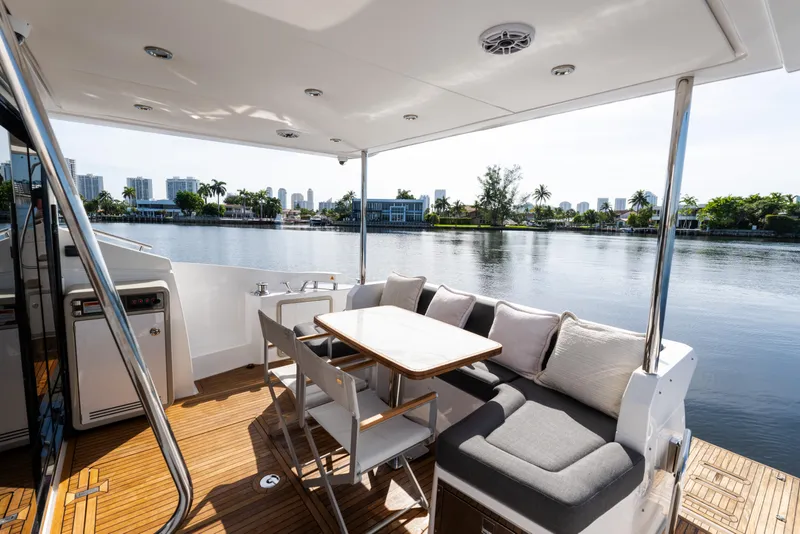 Slide: The Image of Luxurious 2023 Azimut Fly 50 yacht deck with seating, table, and scenic waterfront view. - 17