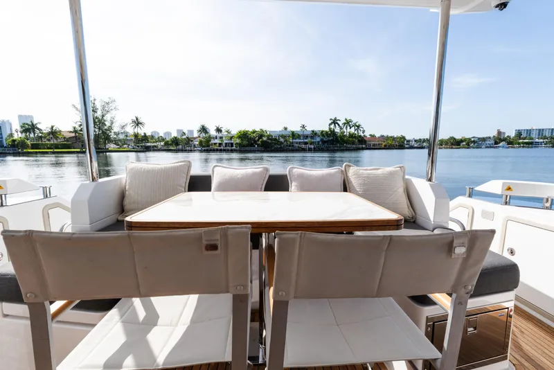 Slide: The Image of 2023 Azimut Fly 50 yacht deck with dining area overlooking serene waterfront. - 19