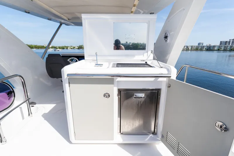 Slide: The Image of 2023 Azimut Fly 50 yacht deck with outdoor kitchen and scenic water view. - 37