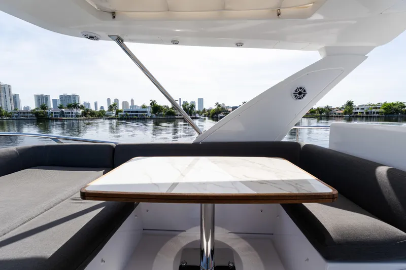 Slide: The Image of 2023 Azimut Fly 50 yacht with elegant seating and table, overlooking waterfront skyline. - 50