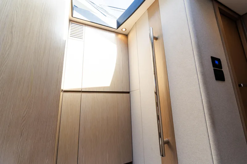 Slide: The Image of Interior of 2023 Azimut Fly 50 yacht, featuring modern wood paneling and skylight. - 83