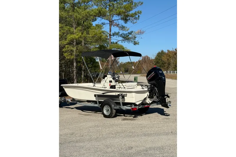 The Image of 2024 Mako Pro Skiff 15 CC on trailer, parked outdoors near trees. - 0