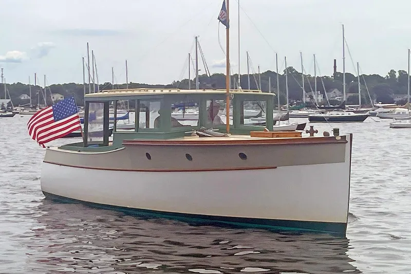 The Image of Classic 1929 Lobster Cruiser boat with American flag, docked in a marina. - 0