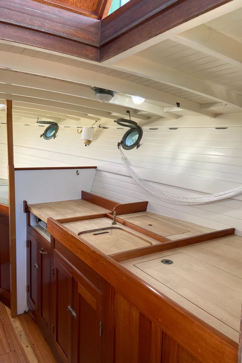Slide: The Image of Interior of a 1929 Classic Lobster Cruiser with wooden cabinetry and portholes. - 11