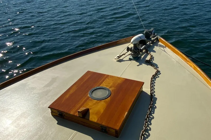 Slide: The Image of 1929 Classic Lobster Cruiser bow with wooden hatch and anchor chain on calm water. - 19