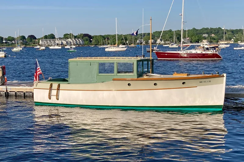 Slide: The Image of Classic 1929 Lobster Cruiser docked in scenic harbor with sailboats. - 2