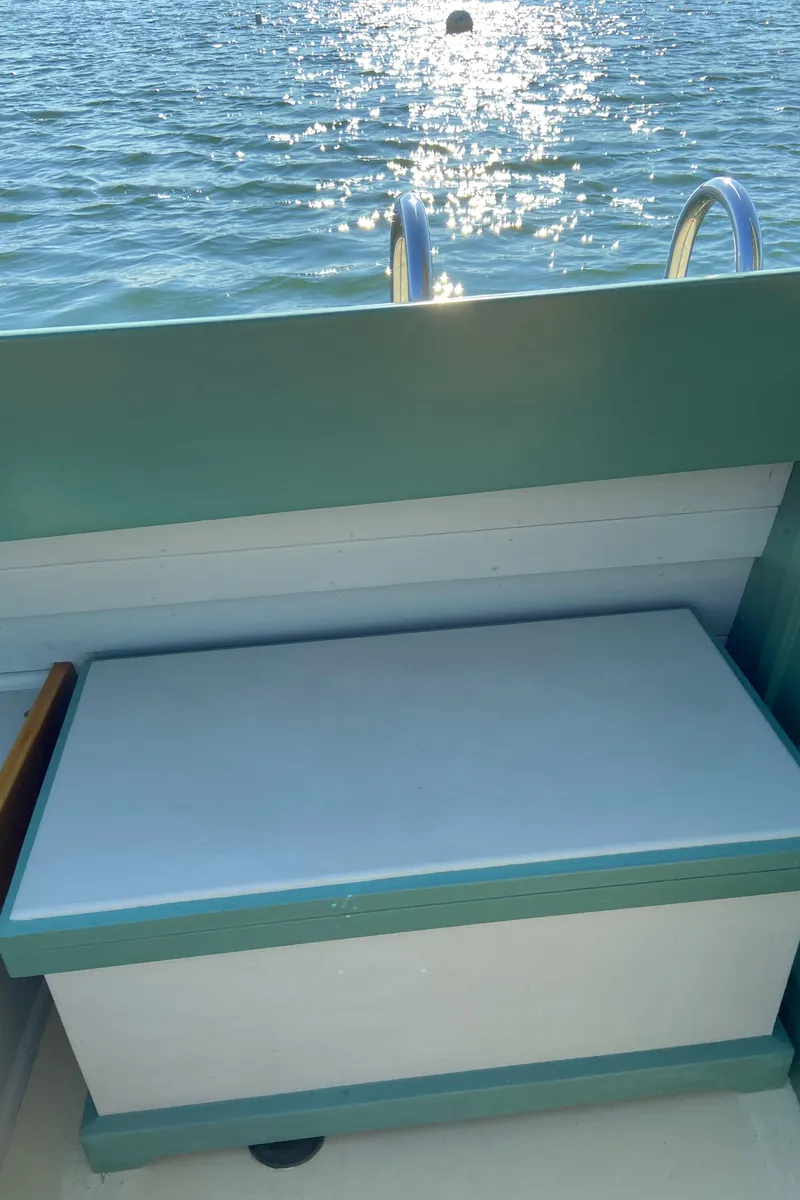 Slide: The Image of 1929 Classic Lobster Cruiser with sunlit water view and seating area. - 21