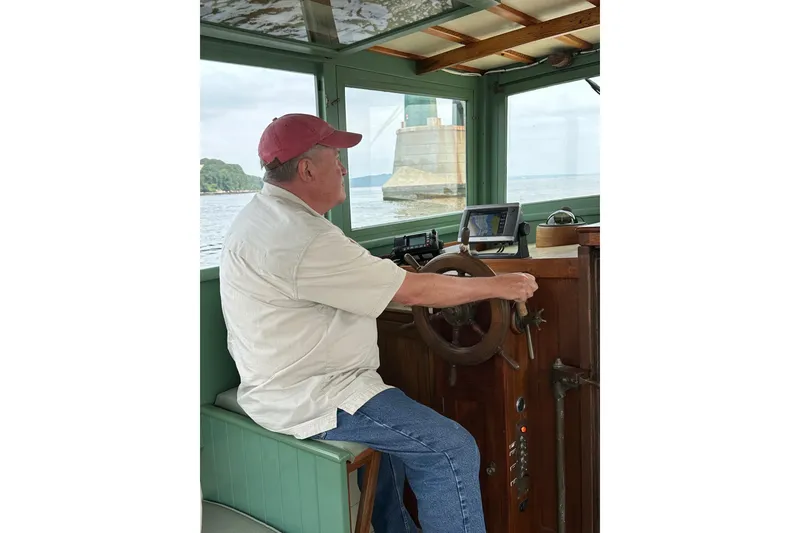 Slide: The Image of Man steering 1929 Classic Lobster Cruiser on a calm waterway. - 24