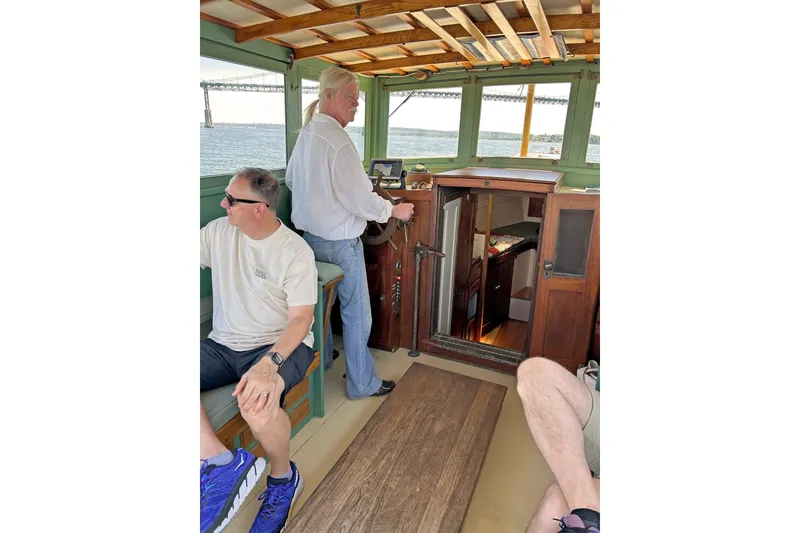 Slide: The Image of 1929 Classic Lobster Cruiser interior with people enjoying a scenic boat ride. - 26