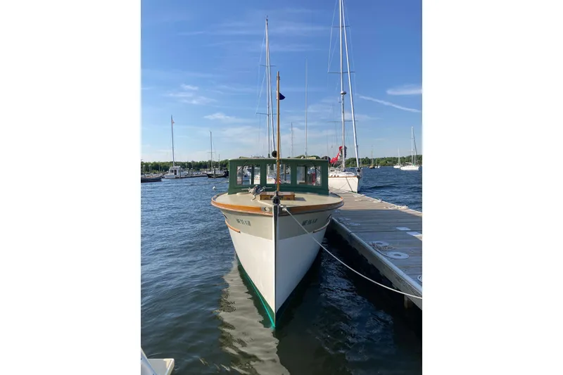 Slide: The Image of Classic 1929 Lobster Cruiser docked at marina under clear blue sky. - 28
