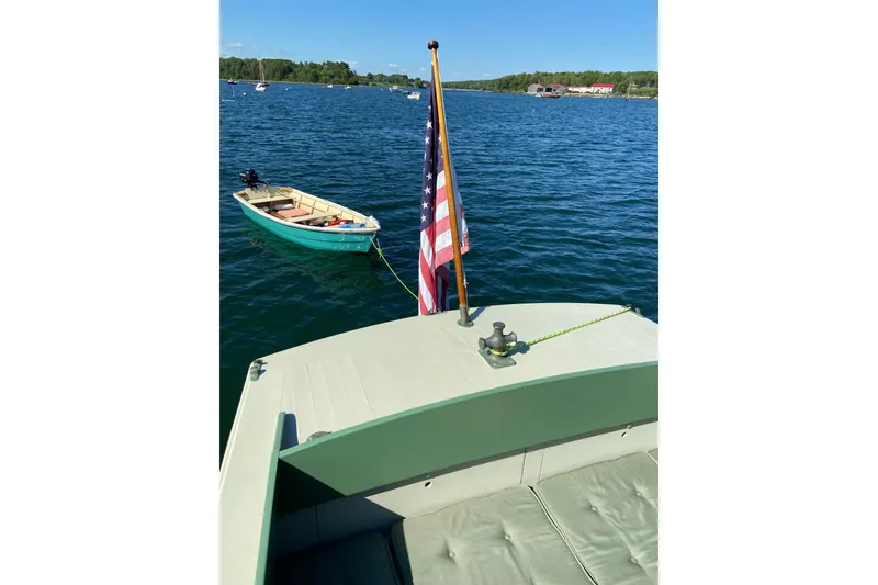 Slide: The Image of Classic 1929 Lobster Cruiser on serene lake with American flag and small boat. - 31