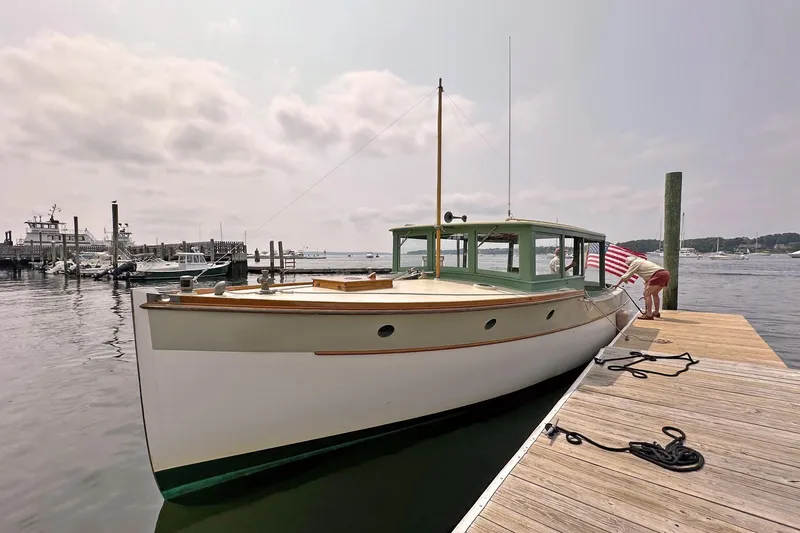 Slide: The Image of 1929 Classic Lobster Cruiser docked at a marina, featuring vintage design and American flag. - 4