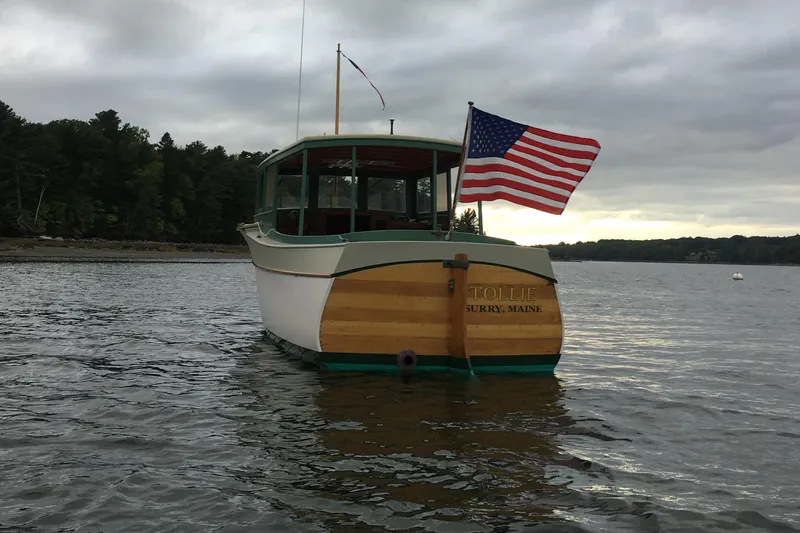 Slide: The Image of Classic 1929 Lobster Cruiser with American flag on calm water, overcast sky. - 5