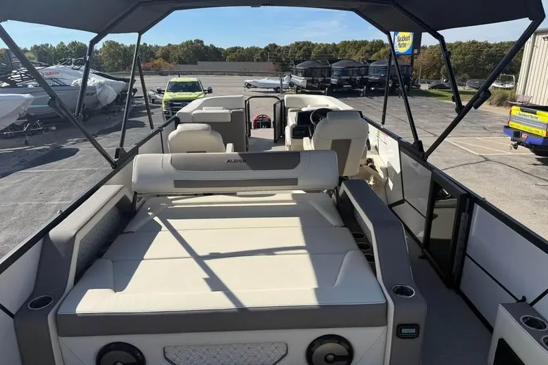 Slide: The Image of Alera M 25Q 2026 boat with spacious seating and canopy in a marina setting. - 7
