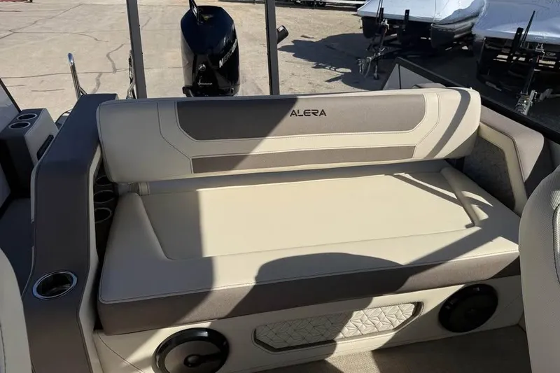 Slide: The Image of 2026 Alera M 25Q boat interior with cushioned seating and cup holders. - 9