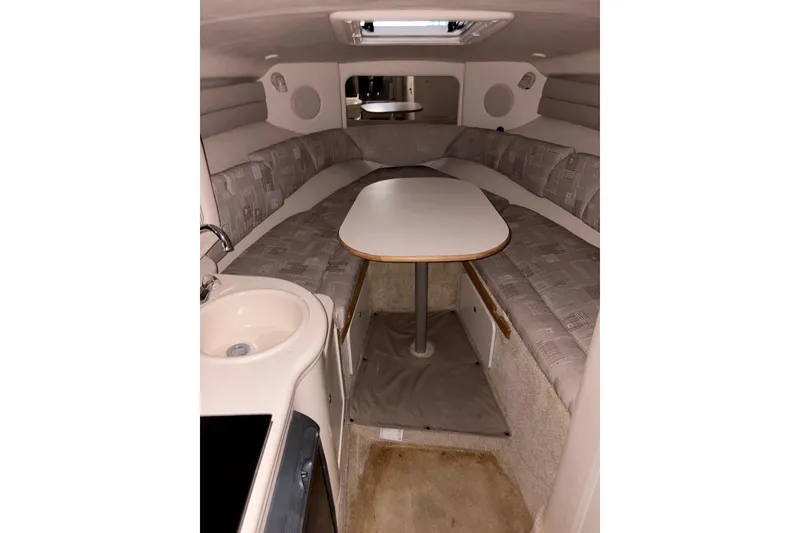 Slide: The Image of 2002 Sea Ray 260 Sundancer cabin interior with seating and table. - 10