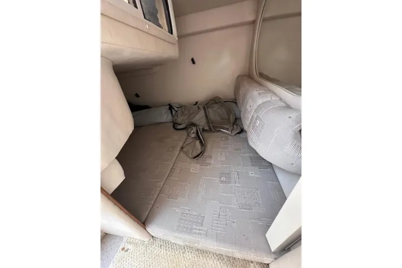 Slide: The Image of 2002 Sea Ray 260 Sundancer cabin interior with cushioned seating and storage. - 16
