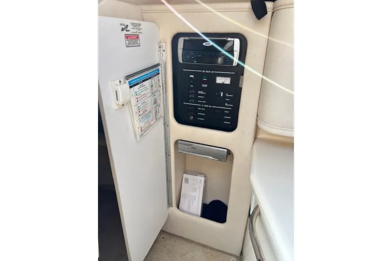 Slide: The Image of 2002 Sea Ray 260 Sundancer electrical panel with open cabinet door. - 19
