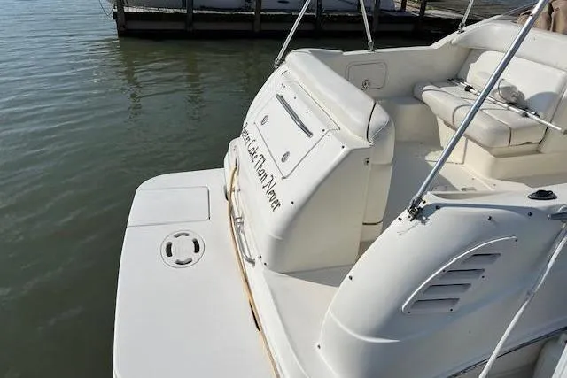 Slide: The Image of 2002 Sea Ray 260 Sundancer boat docked, featuring spacious seating and sleek design. - 3