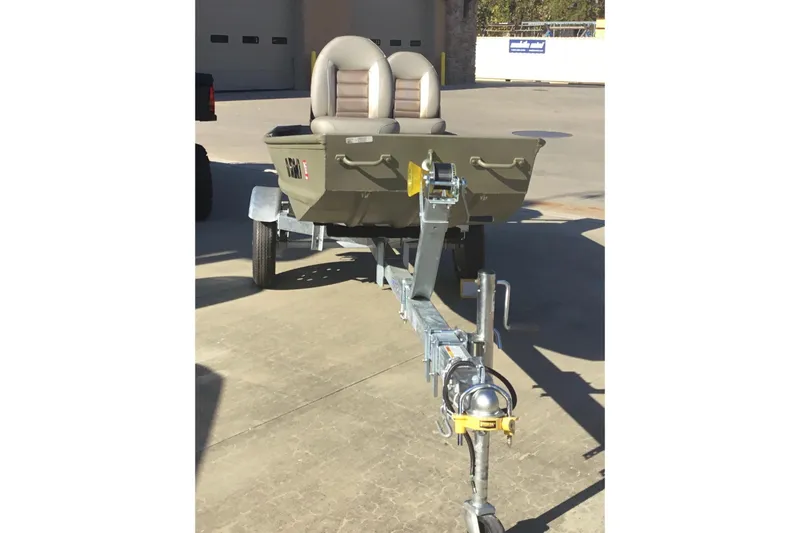 Slide: The Image of 2024 Tracker Grizzly 1236 Jon boat on trailer, featuring dual seats, parked outdoors. - 3