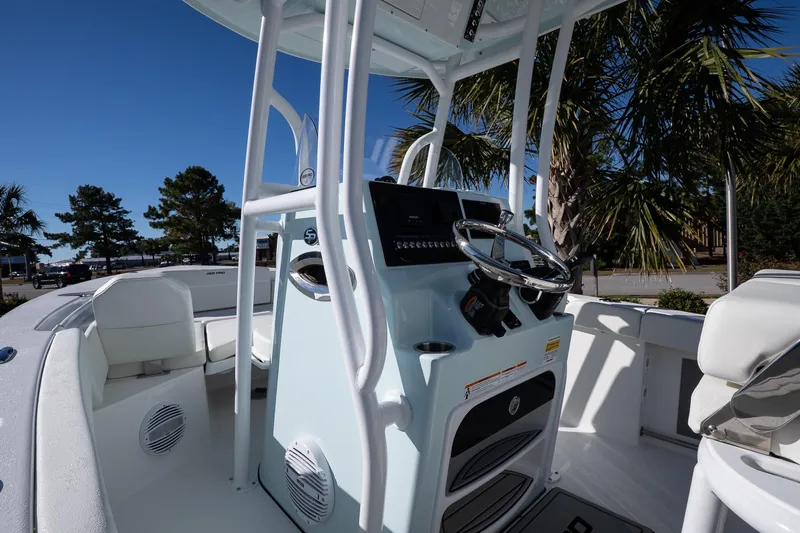 Slide: The Image of 2026 Sea Pro 225FLX Sandbar boat interior with steering console and seating under clear blue sky. - 13