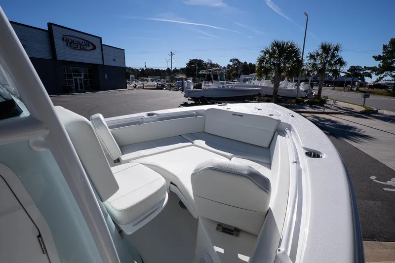 Slide: The Image of 2026 Sea Pro 225FLX Sandbar boat with white seating, parked near dealership. - 17