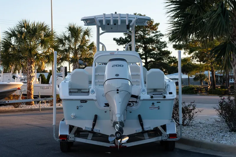 Slide: The Image of 2026 Sea Pro 225FLX Sandbar boat with outboard motor, parked near palm trees. - 6