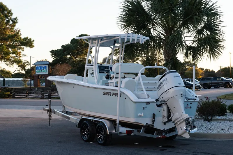 Slide: The Image of 2026 Sea Pro 225FLX Sandbar boat on trailer, parked near palm trees. - 5